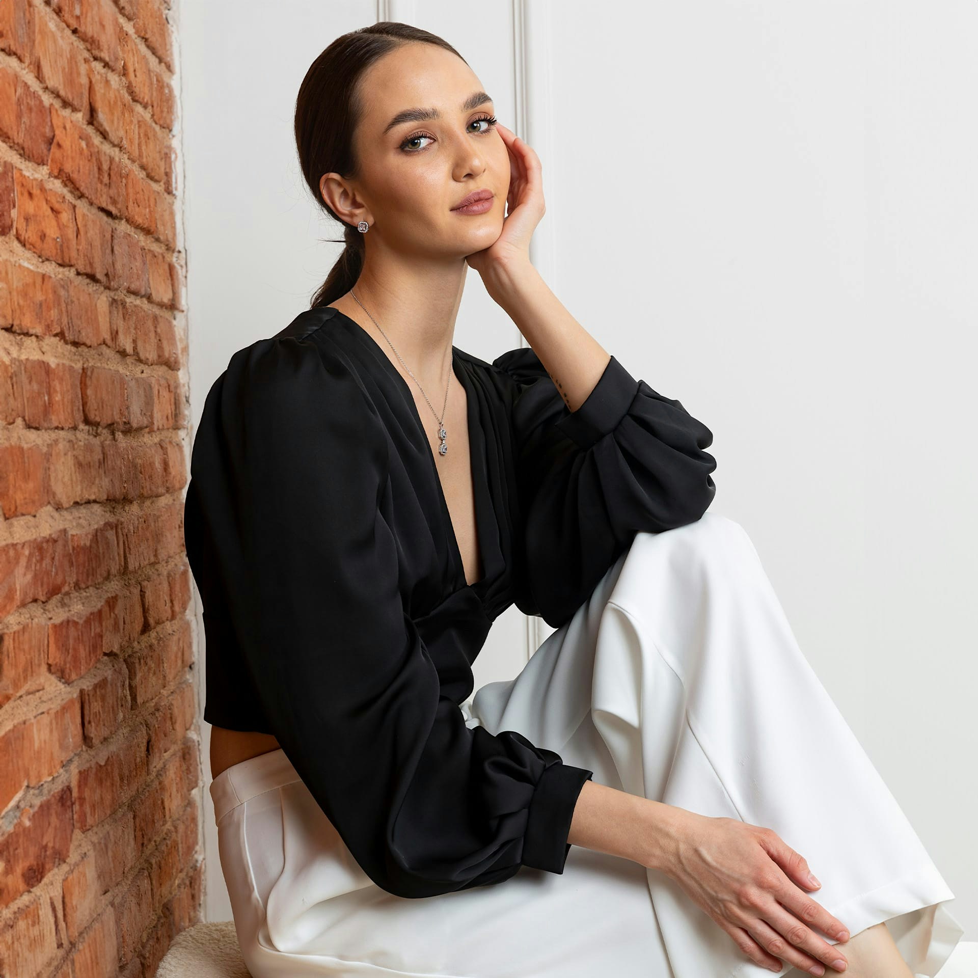 woman in a black blouse and white pants