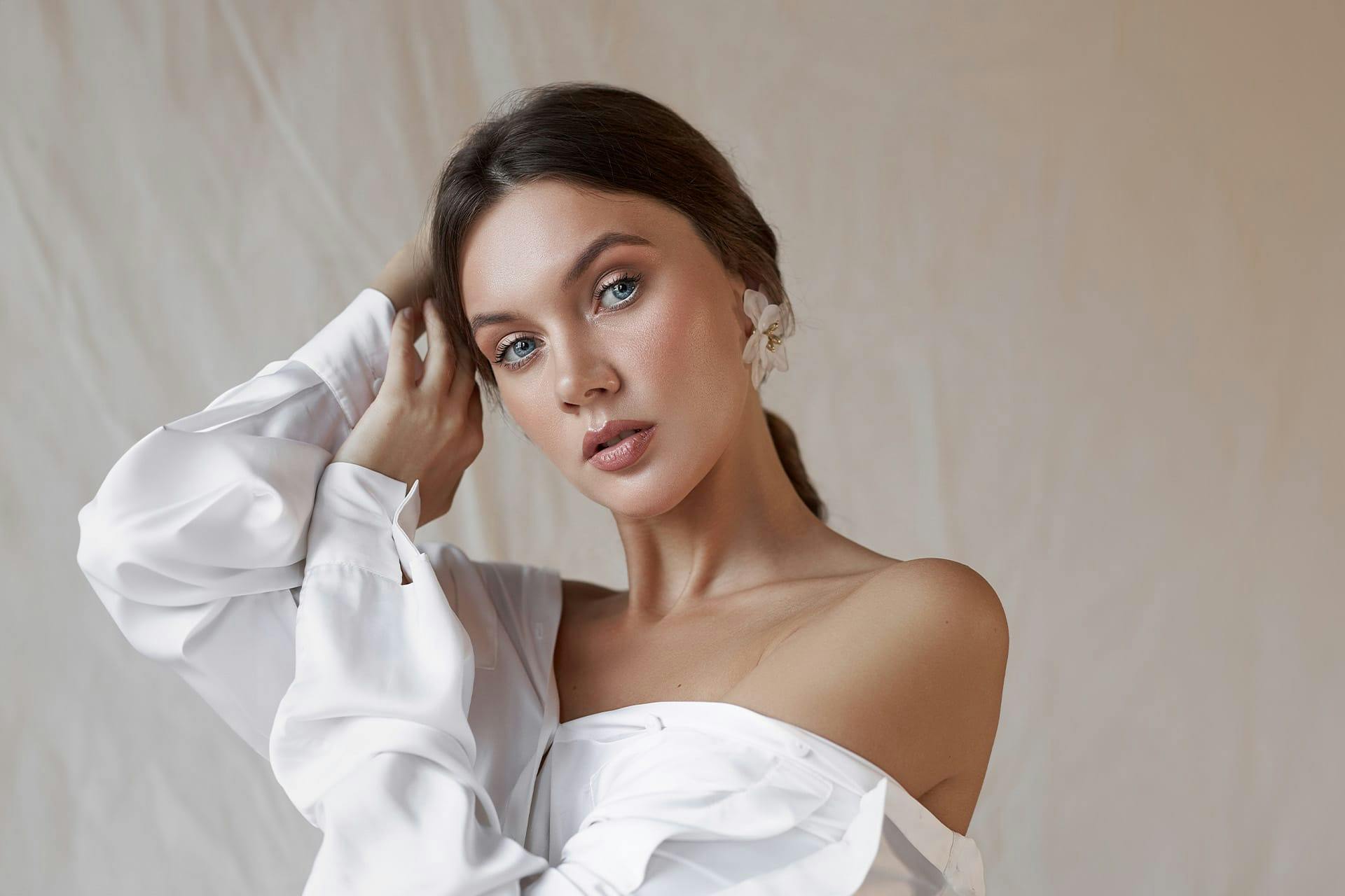 woman in a white button up shirt hanging off the shoulder
