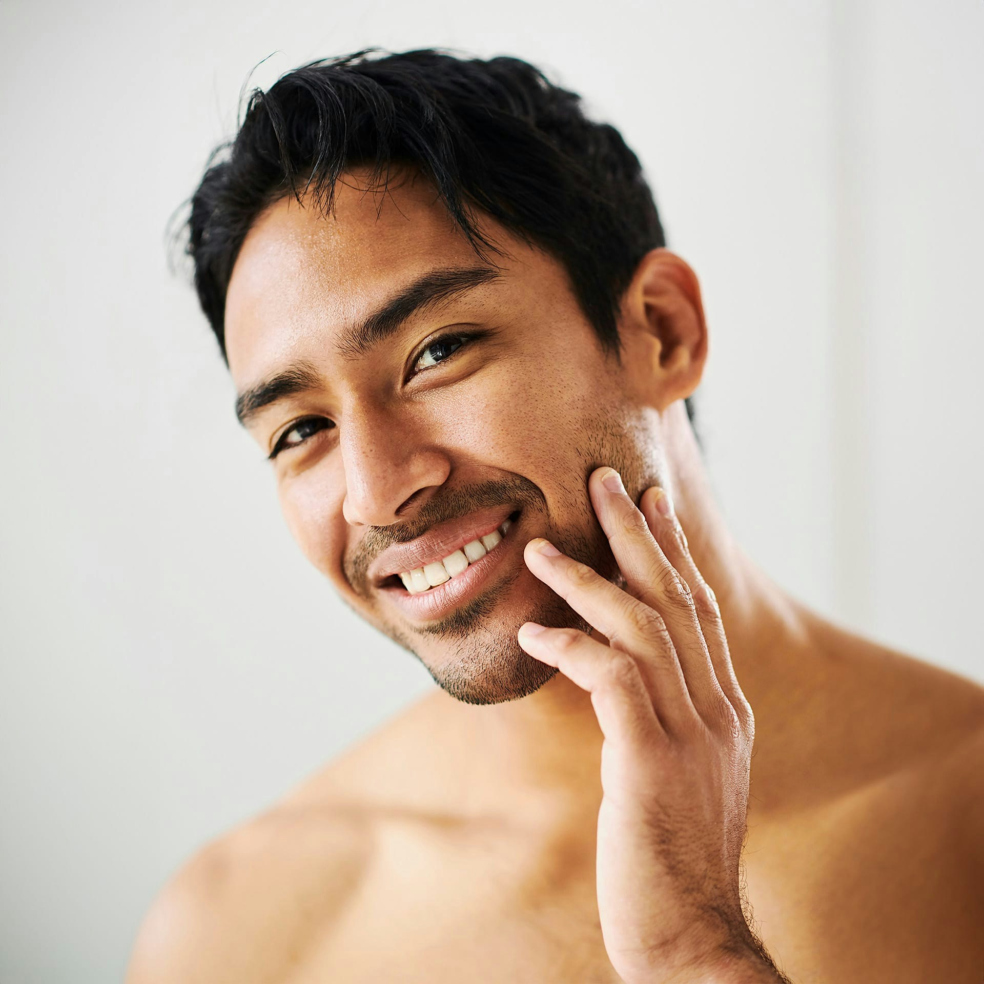 man smiling and touching his jaw area
