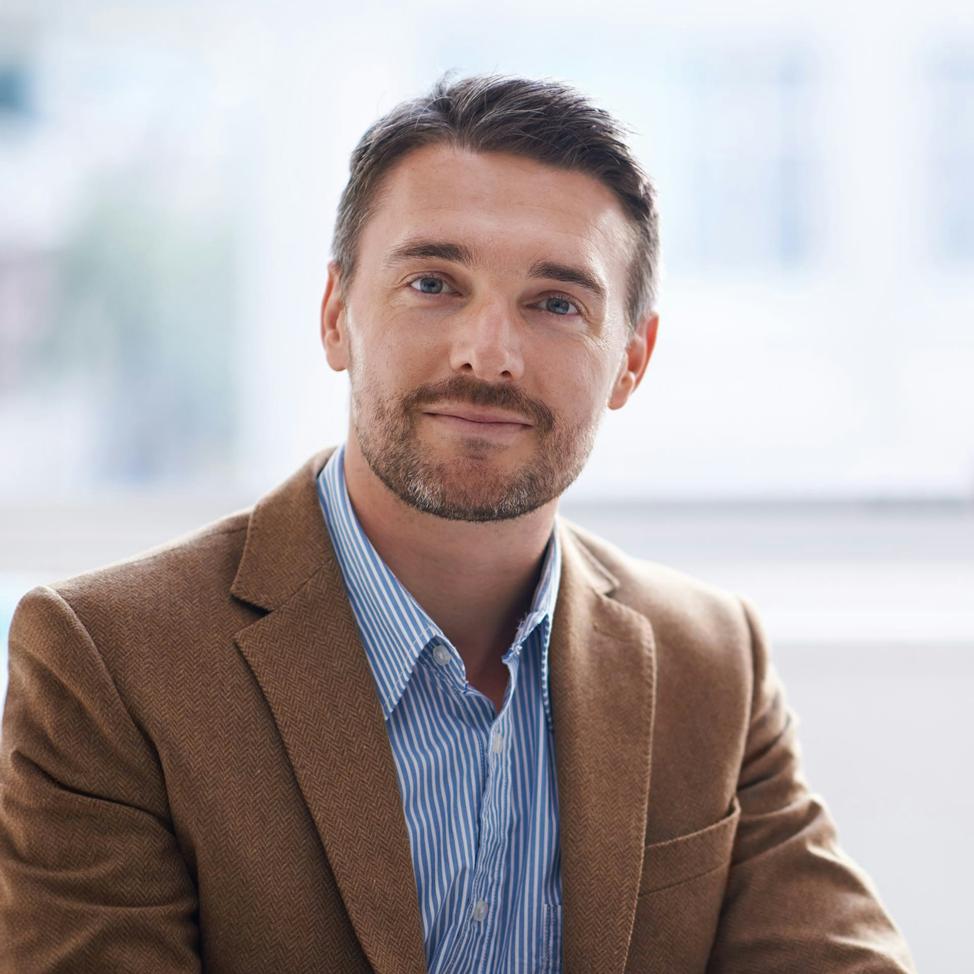 man in a brown suit jacket