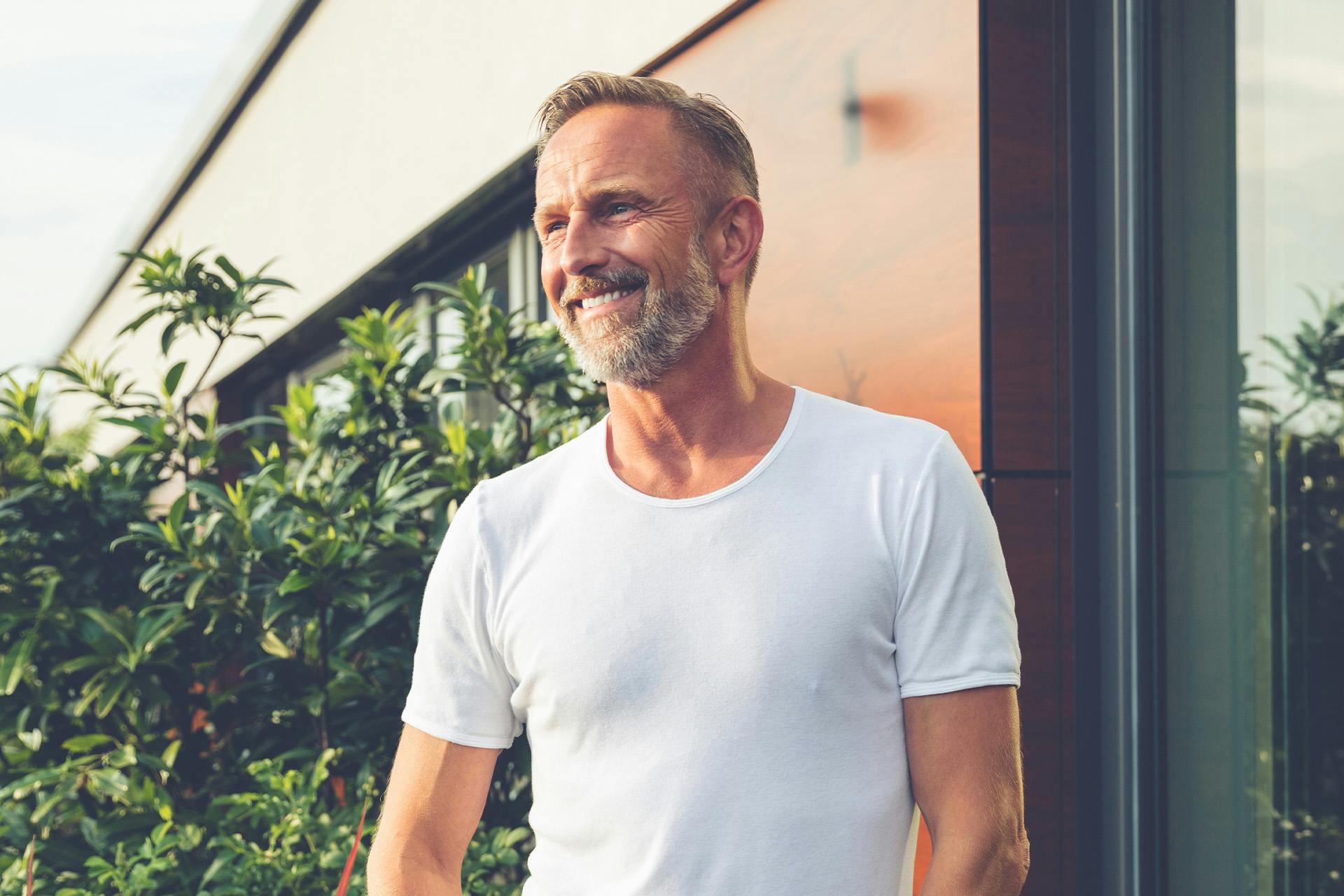 man with a salt and pepper beard wearing a white shirt