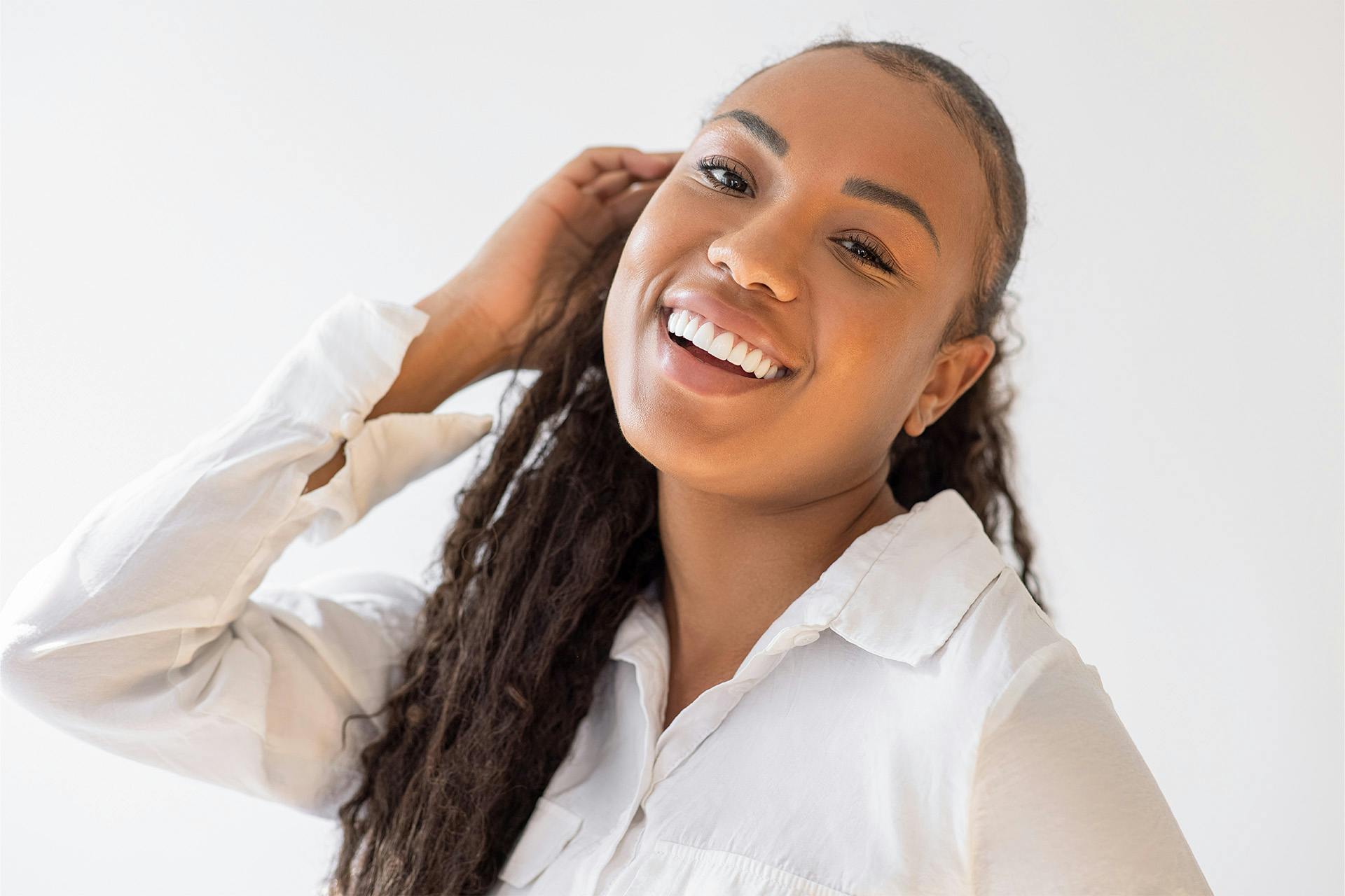 woman with long dark hair wearing a white button up shirt