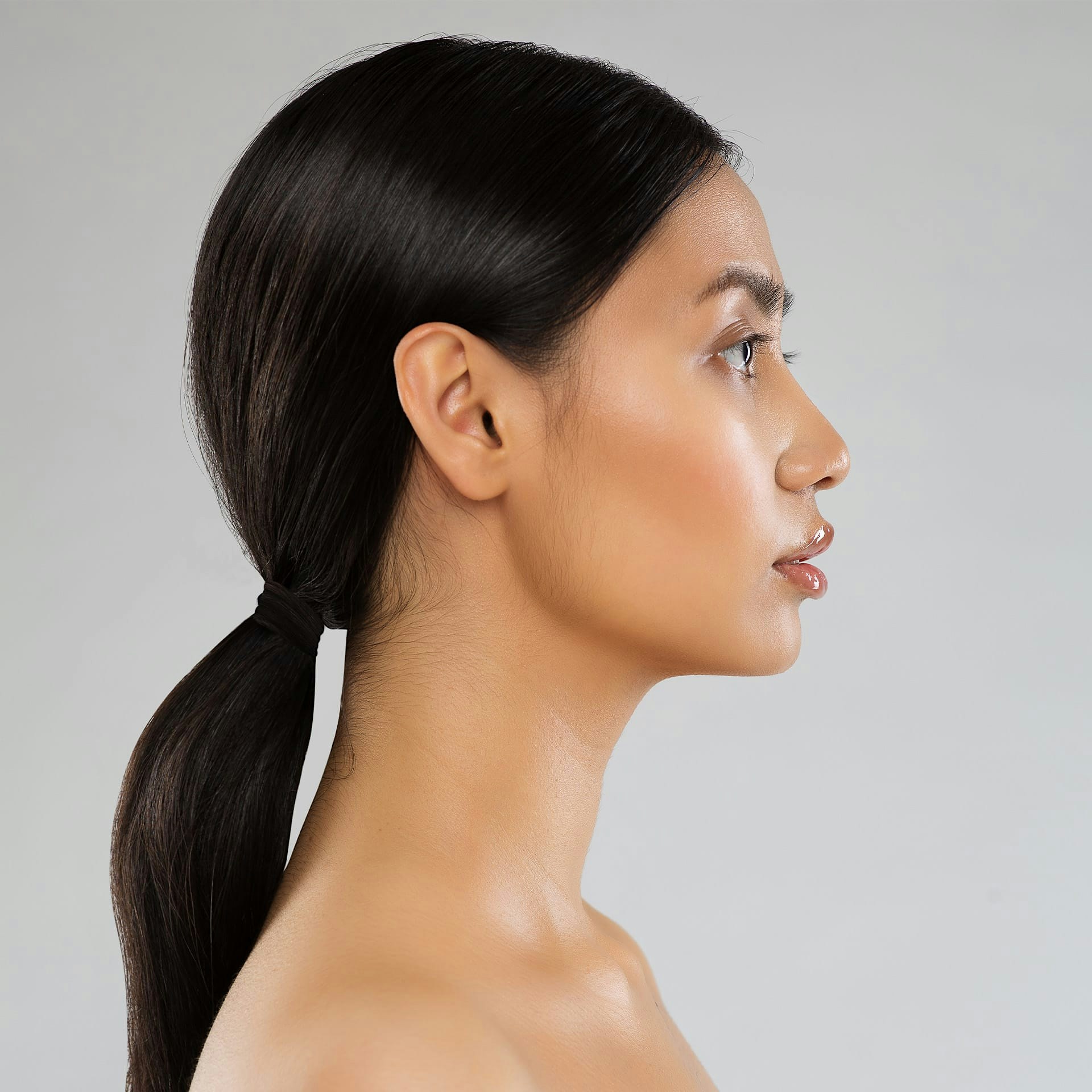 side profile of a woman with her dark hair in a ponytail