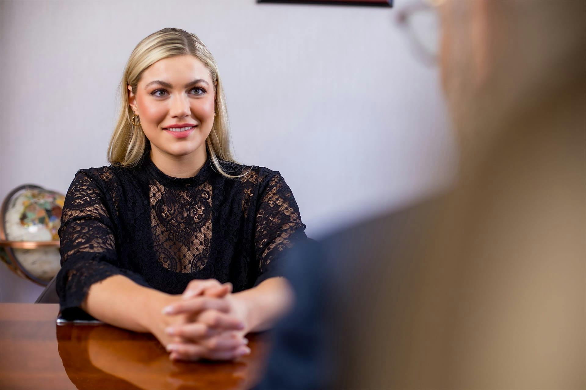 woman sitting down wearing a black lacey top