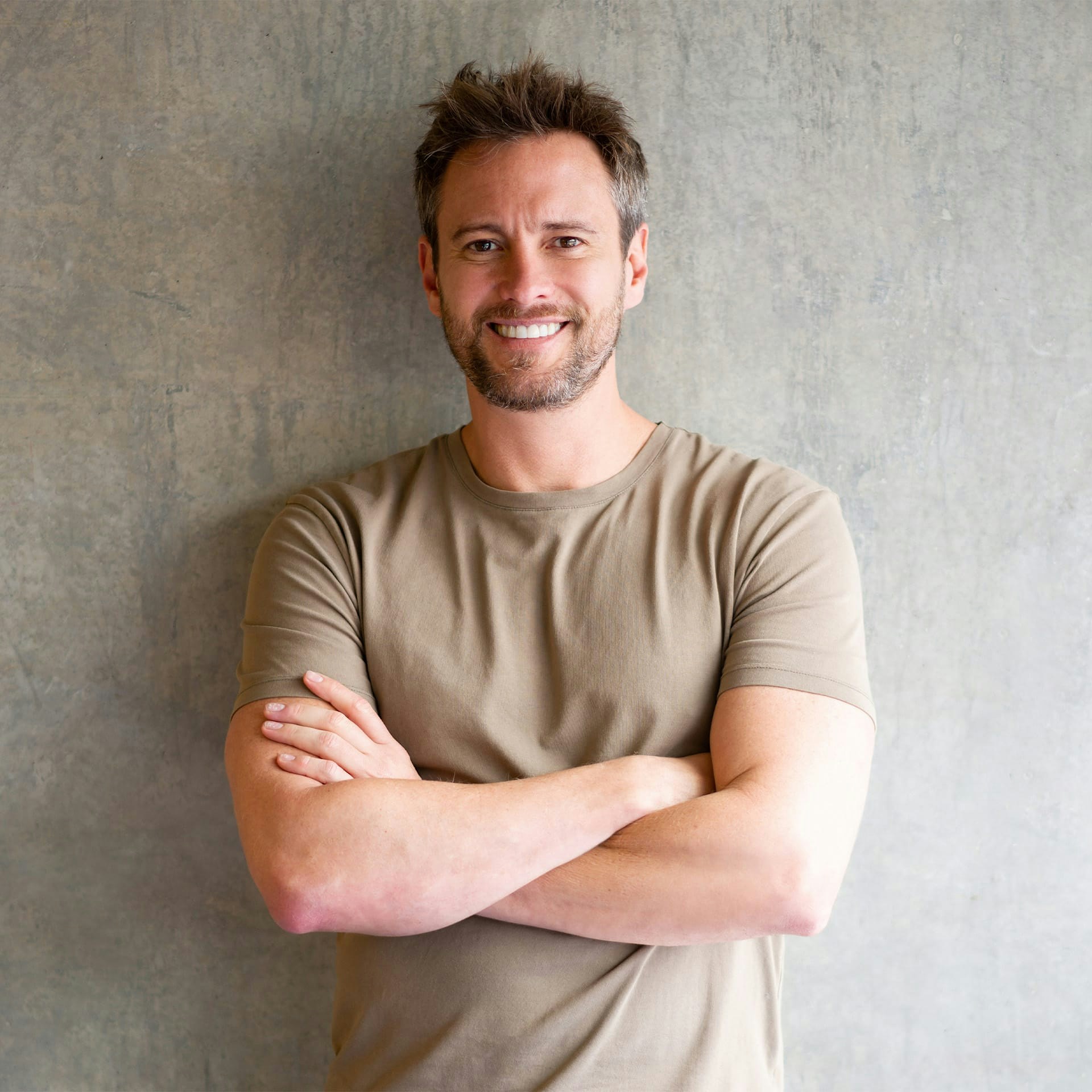 man smiling with his arms crossed