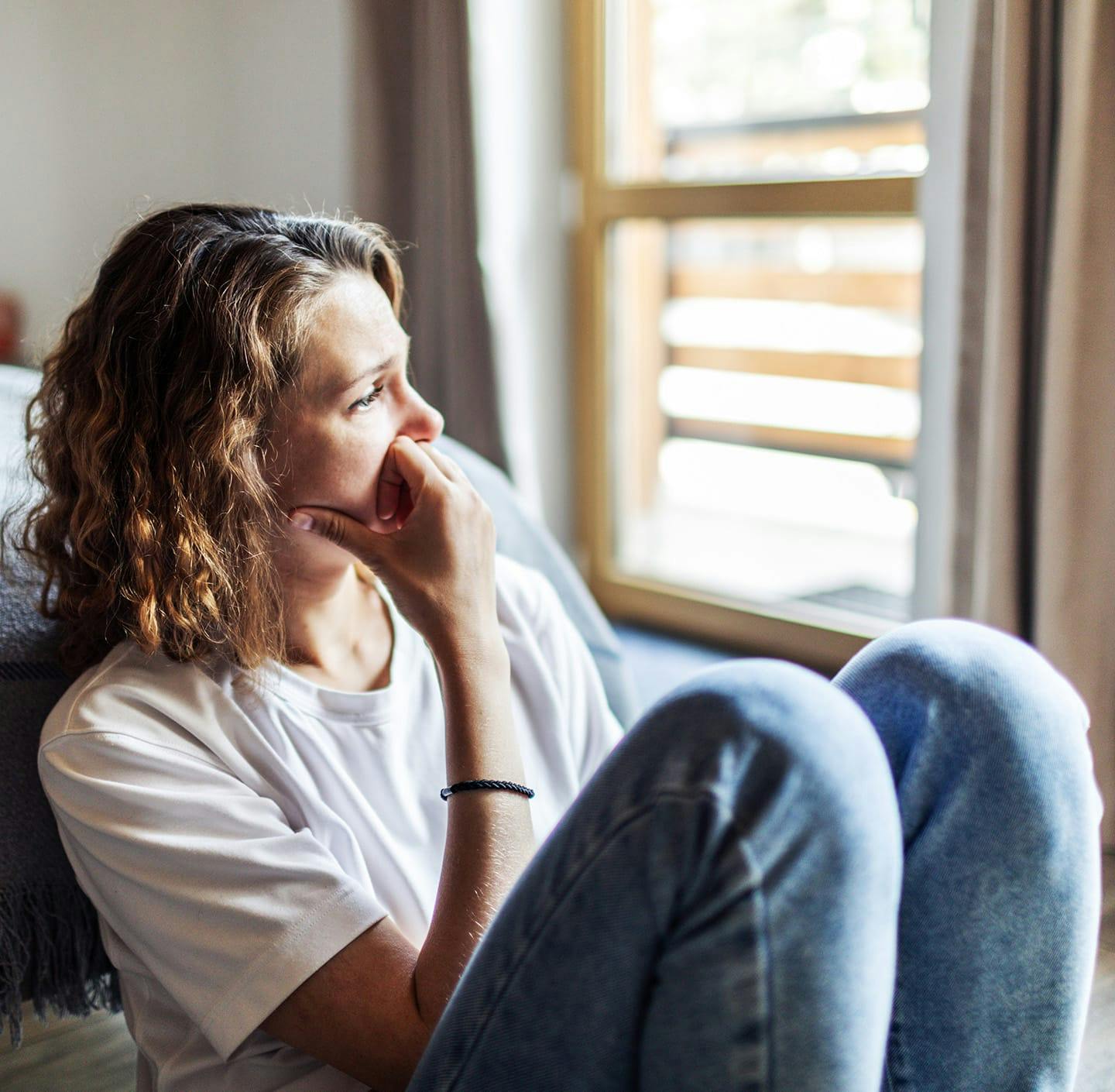 Woman anxiously looking out window