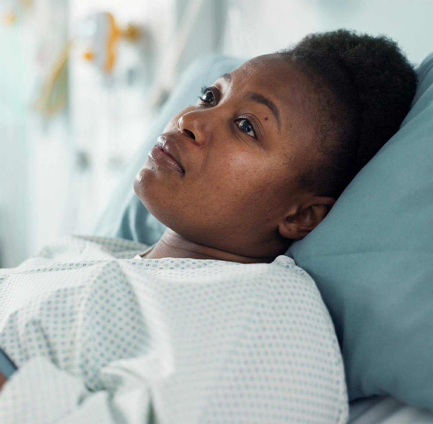 Woman in hospital gown laying in bed