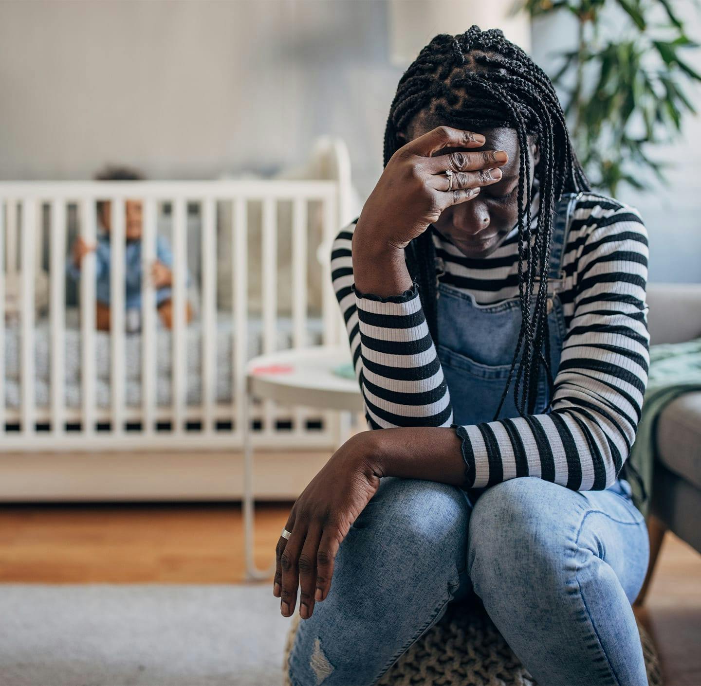 Woman looking upset near child in crib