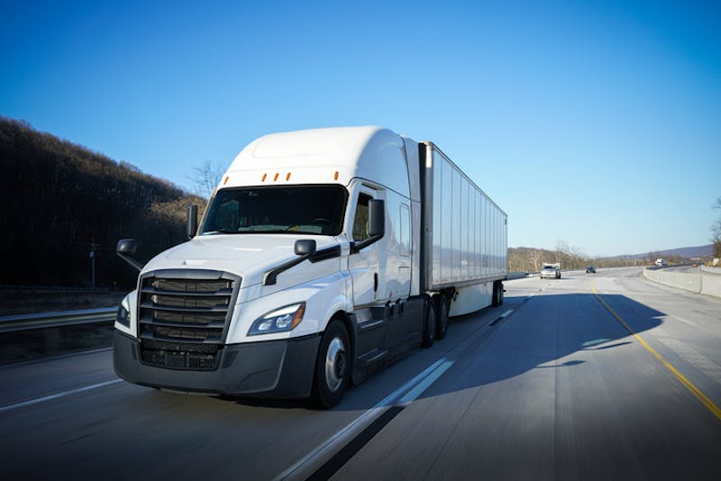 A white commercial truck on road