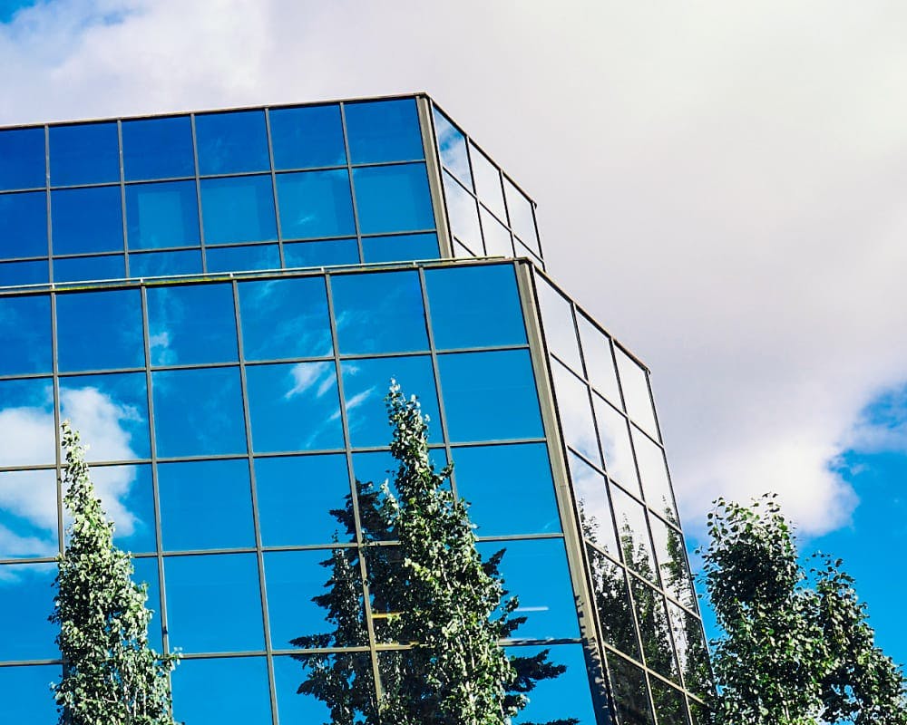 tall glass building reflecting the sky on the windows