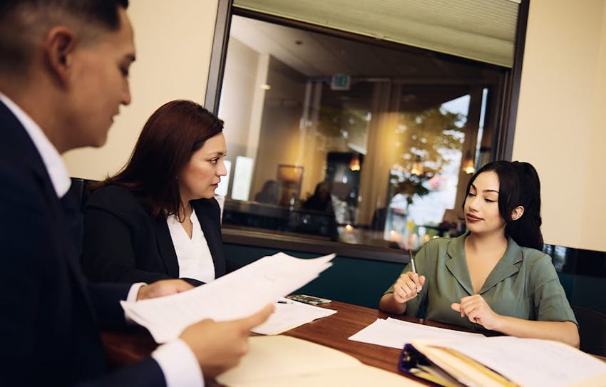 Attorneys at table working on paperwork together