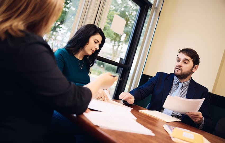 attorneys working together with client on paperwork