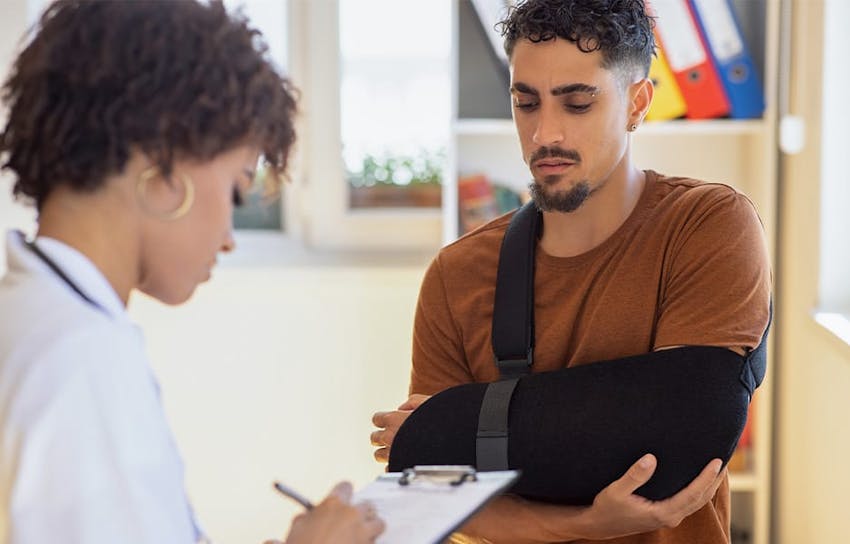 man with arm brace on speaking to doctor
