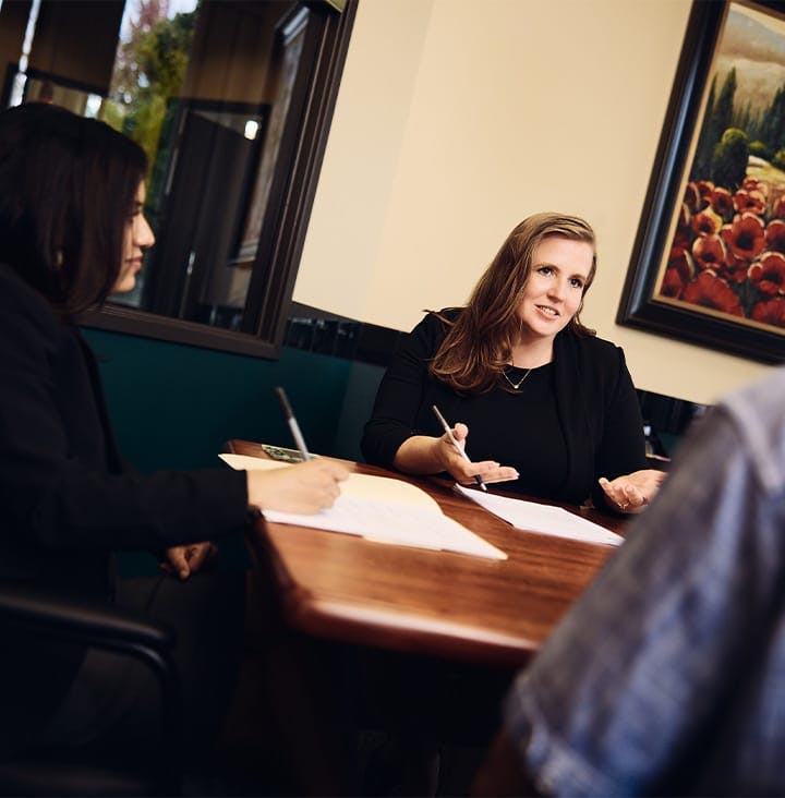 attorneys speaking client with paperwork on table
