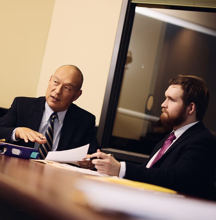 attorneys in suits speaking at table
