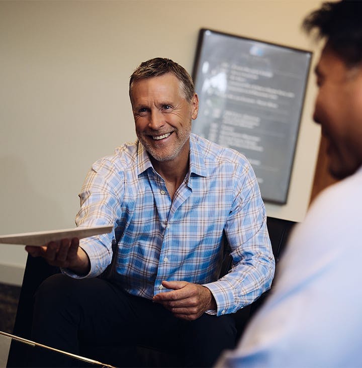 client smiling and handing paperwork to attorney