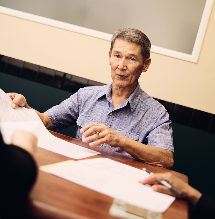 client with attorneys looking at paperwork