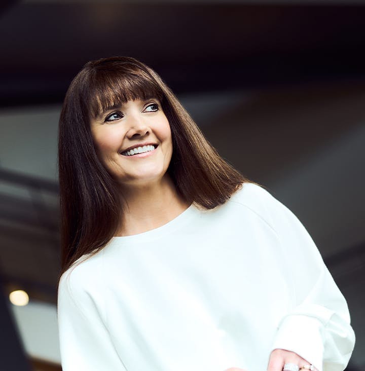 Angel Chenaur smiling in white shirt