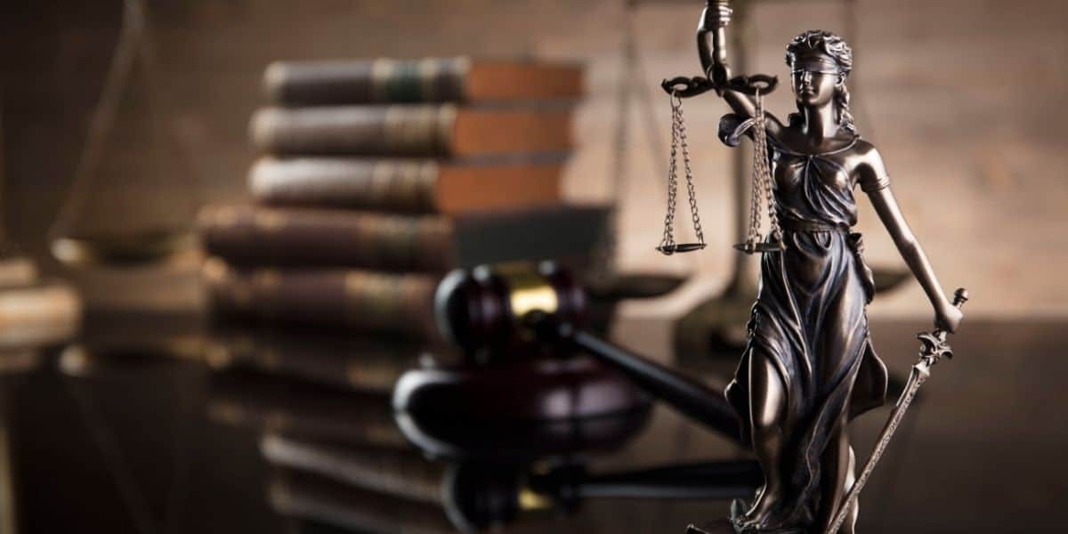 Law books, law gavel and blind justice figure on table