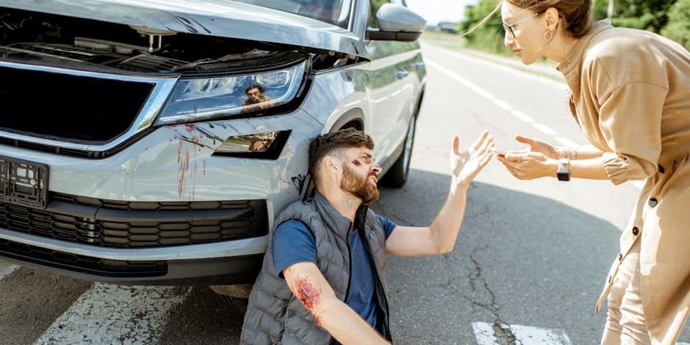 pedestrian injured by car lady helping him