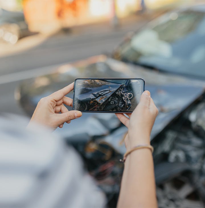 person taking photo of car crash