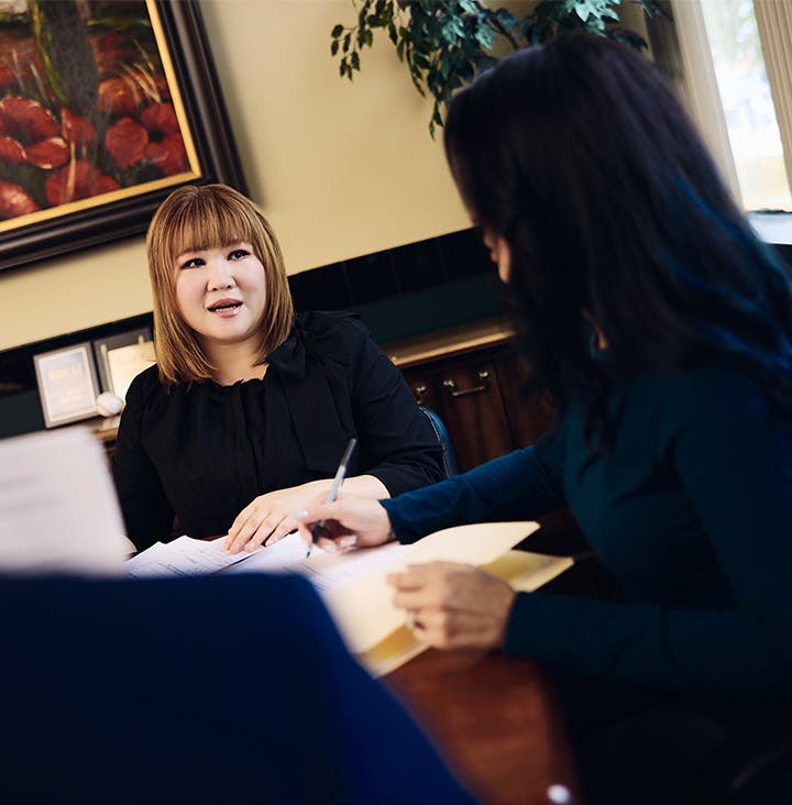 attorney speaking to another attorney at table