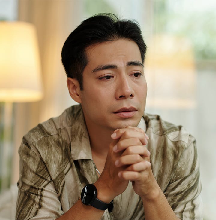 man holding his hands together under his chin