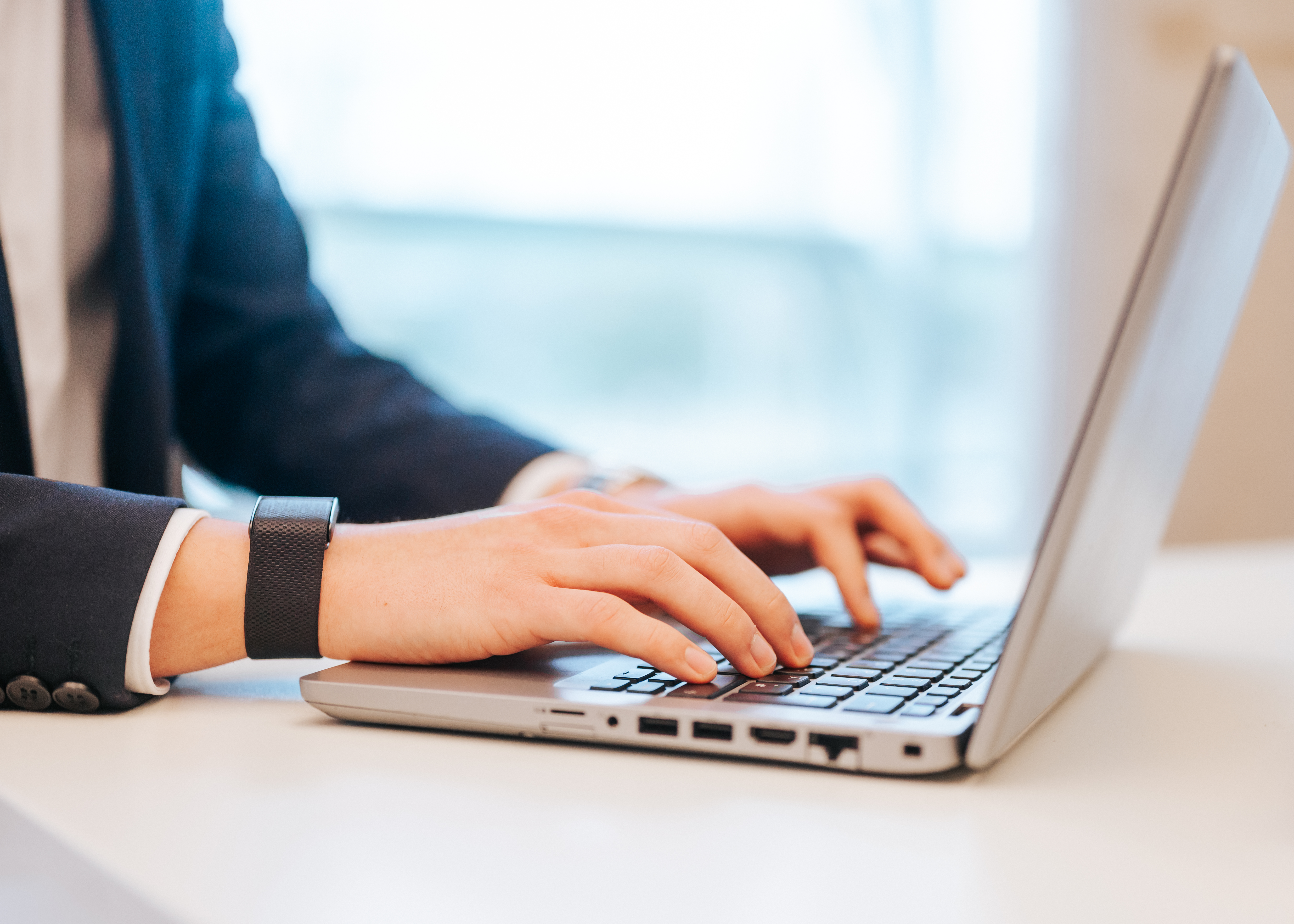 Nahaufnahme von Händen auf der Laptop-Tastatur im Büro.