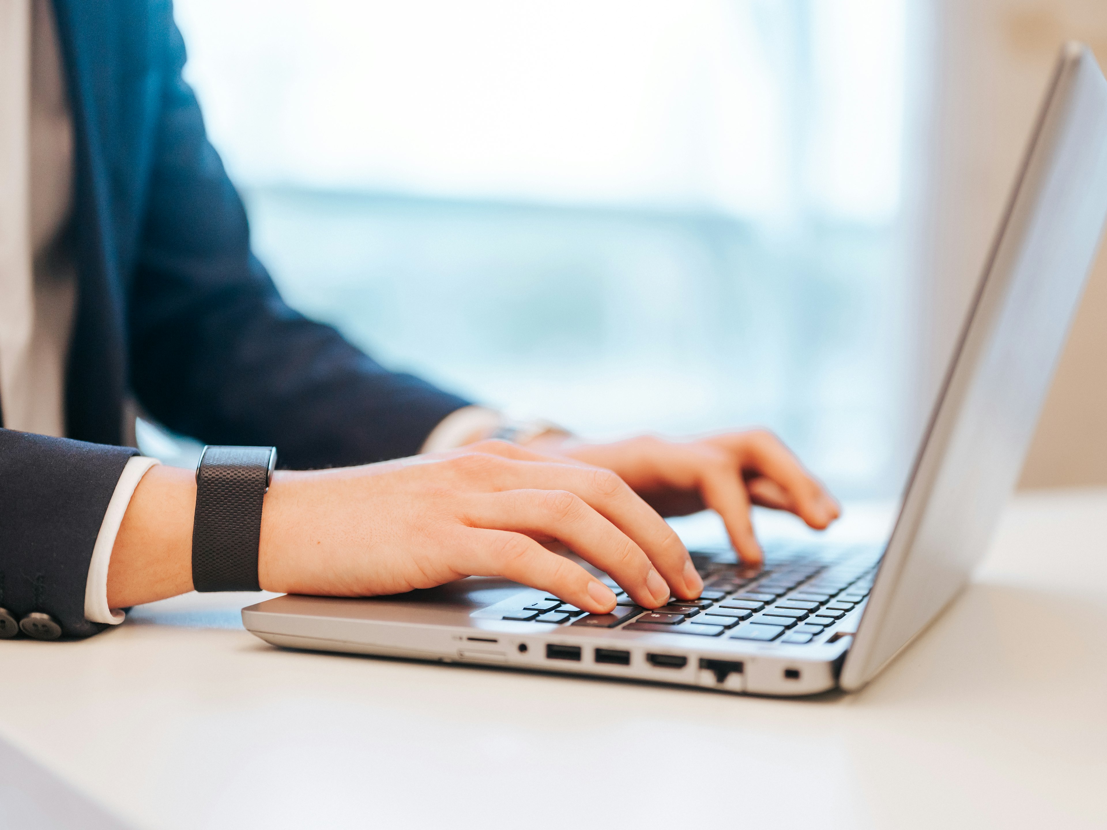 Nahaufnahme von Händen auf der Laptop-Tastatur im Büro.