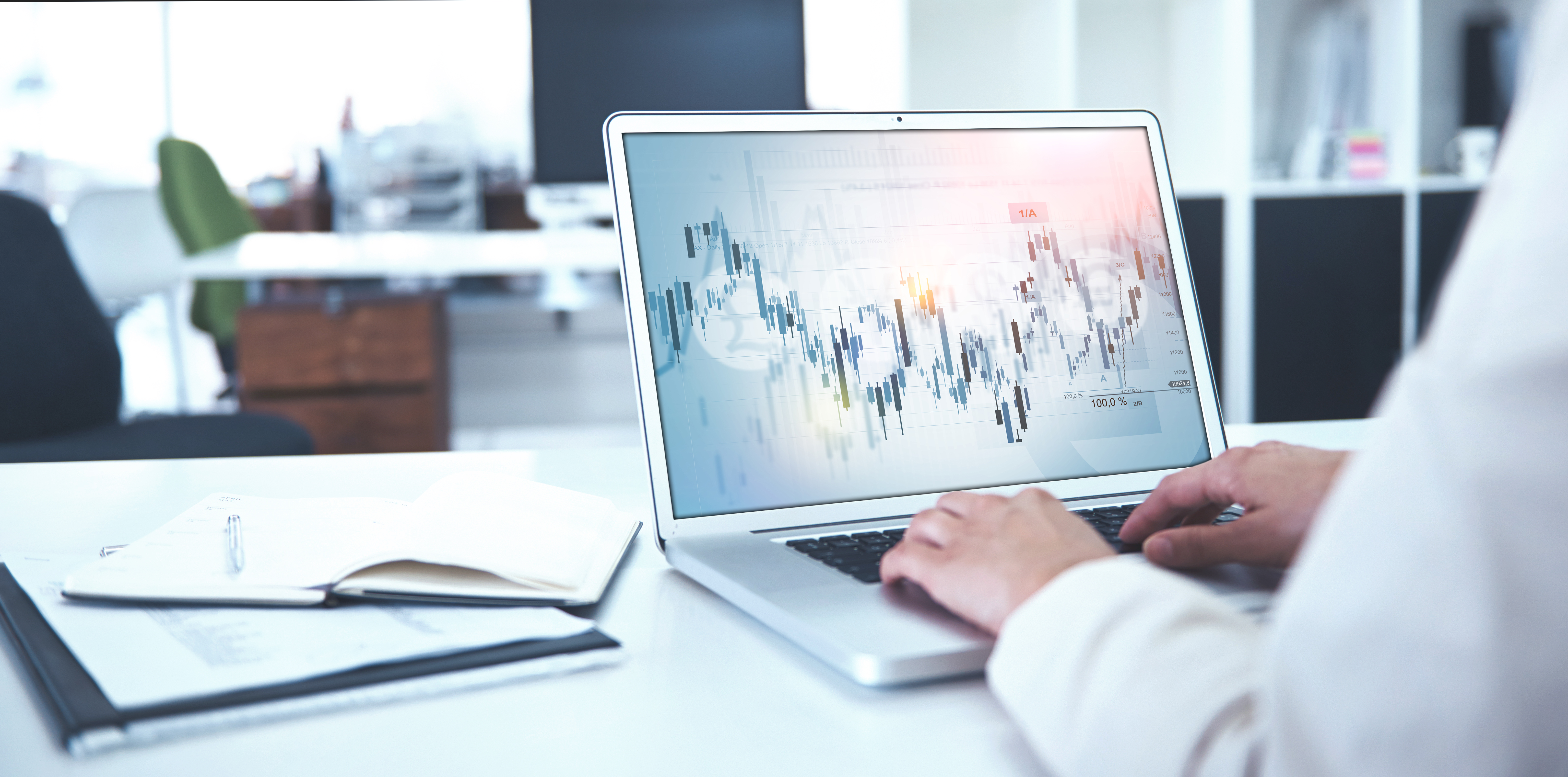 Laptop mit geöffnetem Finanzchart, Mitarbeitender der Baaderbank analysiert Börsendaten.