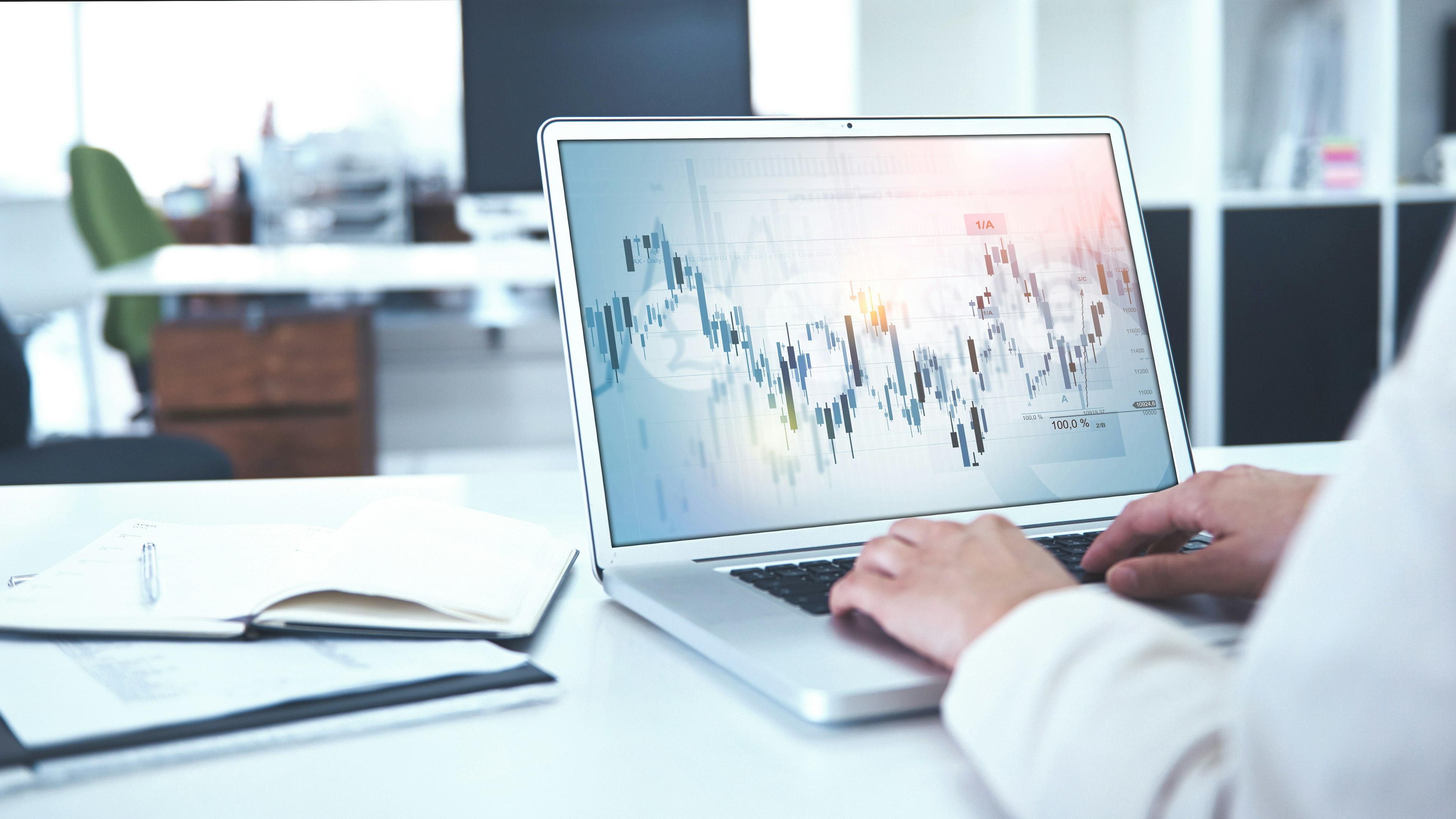 Laptop mit geöffnetem Finanzchart, Mitarbeitender der Baaderbank analysiert Börsendaten.