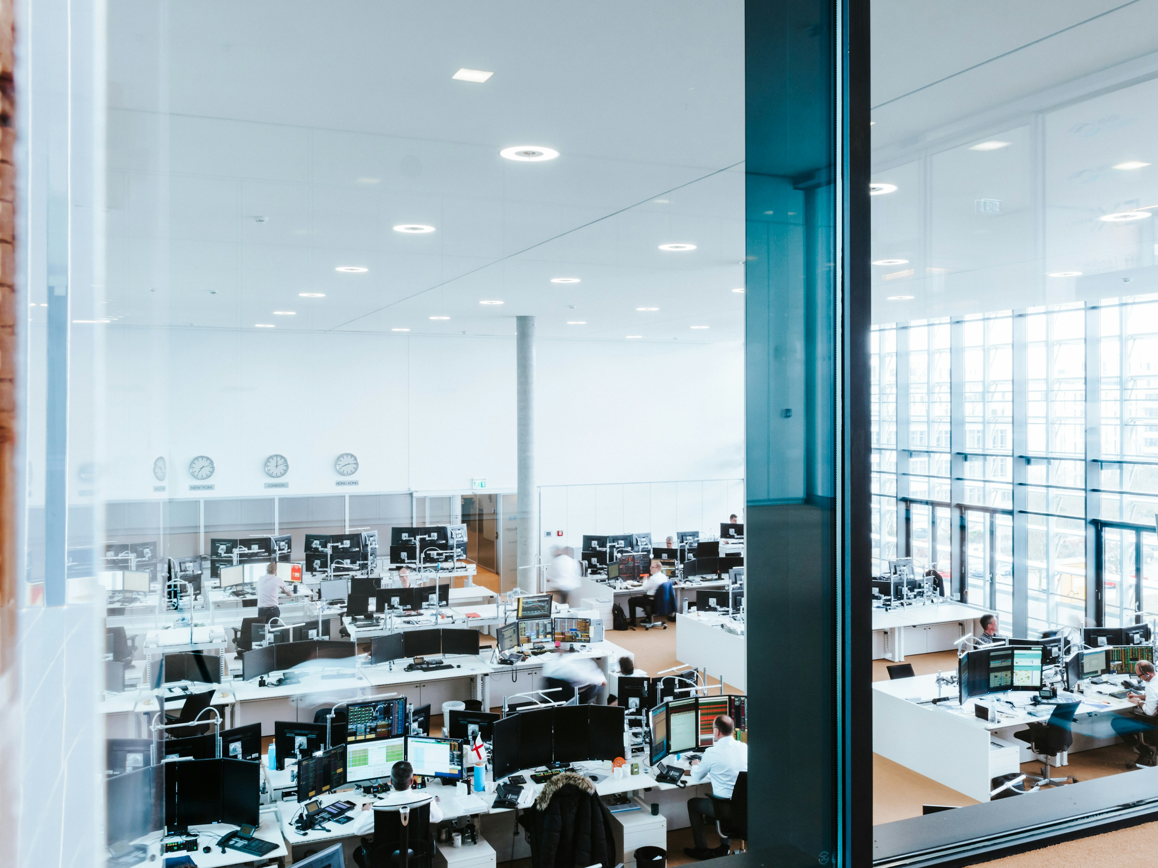 Heller Raum der Baaderbank mit zahlreichen Monitoren und Mitarbeitenden an modernen Handelsarbeitsplätzen.