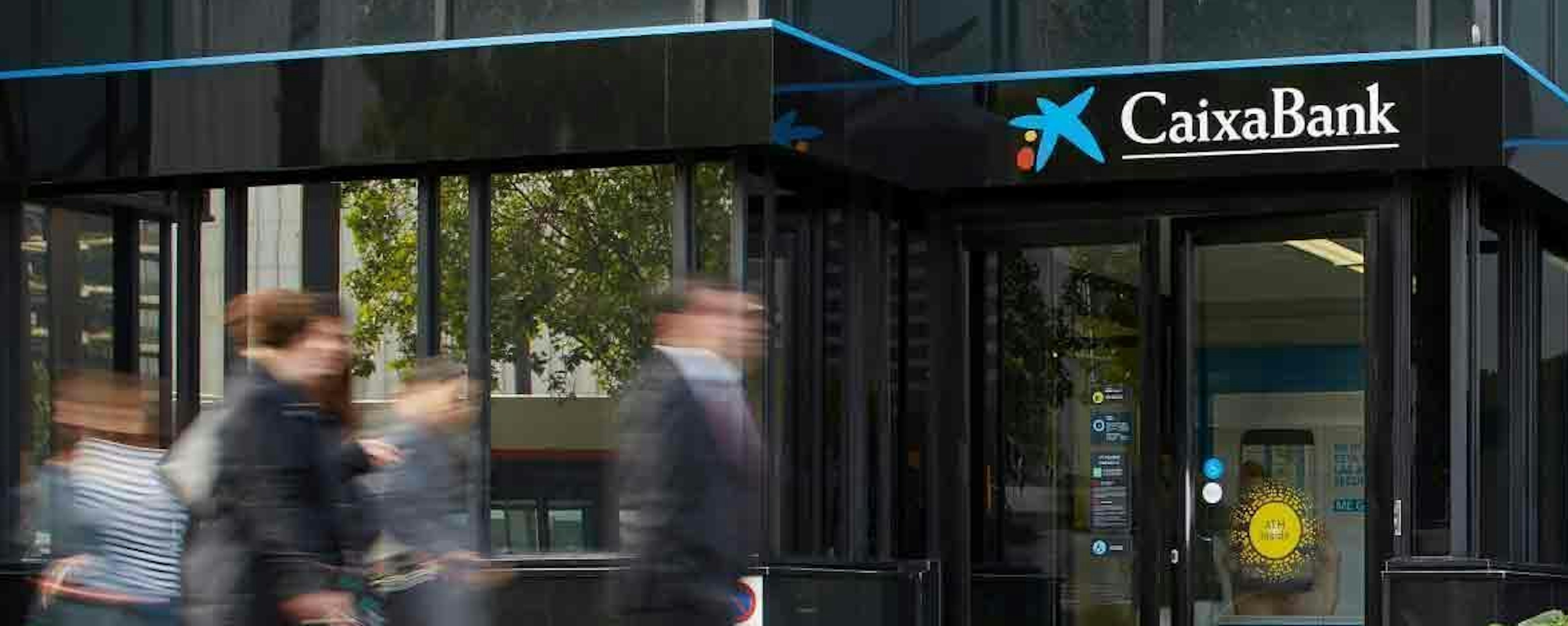 Eingangsbereich der CaixaBank, Menschen laufen verschwommen vorbei.