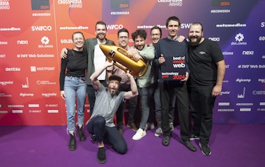 Gold bei Best of Swiss Web für smartive und Frontify Eine Gruppe von acht Personen posiert gemeinsam auf einem violetten Teppich und hält eine goldene Trophäe in Raketenform und eine Plakette mit der Aufschrift „Best of Web Technology Gold 2024“.