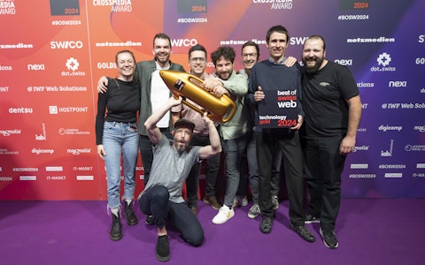 Gold bei Best of Swiss Web für smartive und Frontify Eine Gruppe von acht Personen posiert gemeinsam auf einem violetten Teppich und hält eine goldene Trophäe in Raketenform und eine Plakette mit der Aufschrift „Best of Web Technology Gold 2024“.