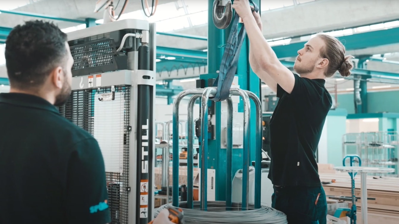 Zwei Mitarbeiter von Spühl bei der Montage einer Maschine in einer grossen Fabrikhalle