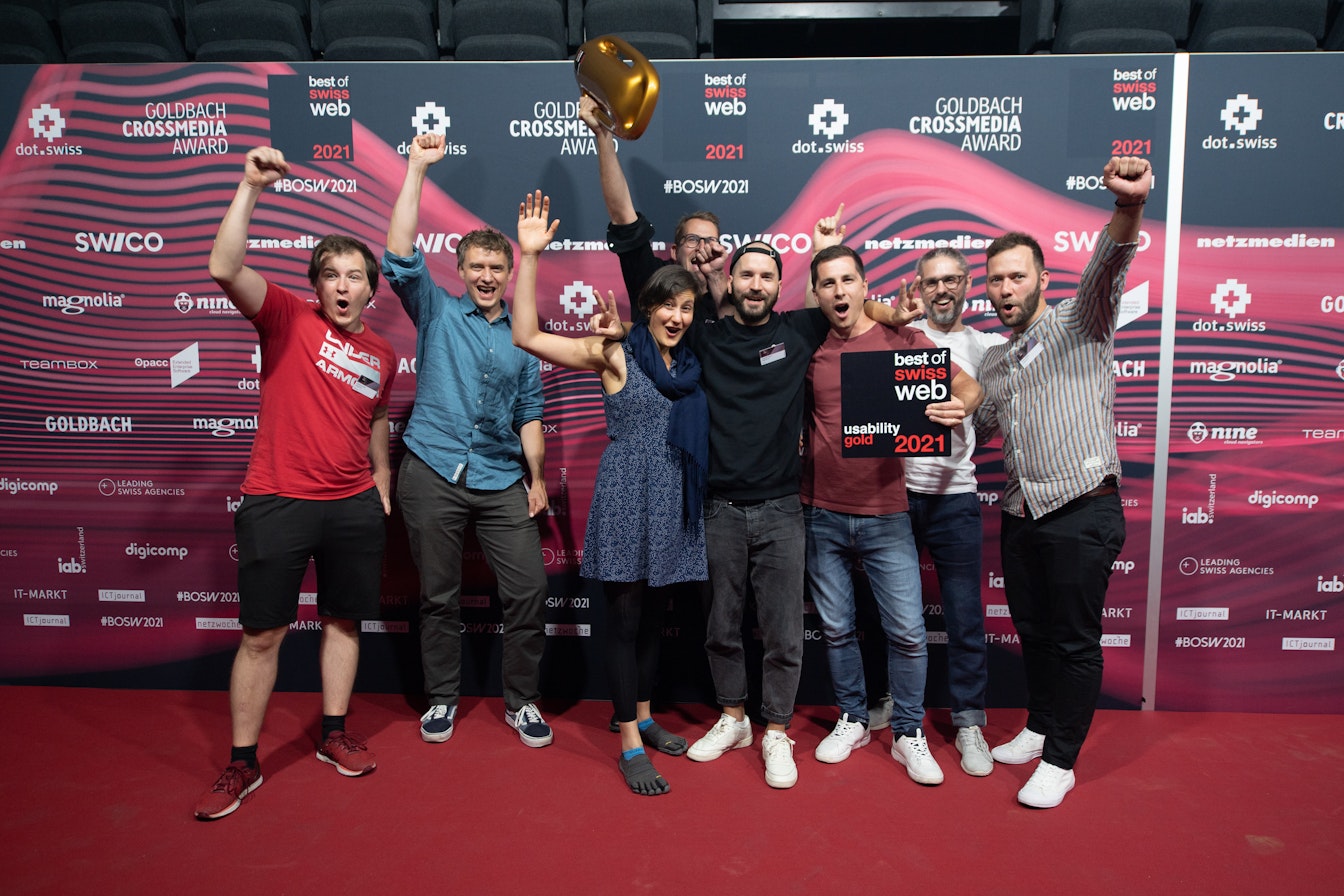 Eine Gruppe Menschen vor der Best of Swiss Web Sponsorenwand während der Siegerehrung