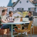 Auf unserer Dachterasse am Standort in St.Gallen Drei Mitarbeiter von smartive sitzen mit ihren Laptops auf der sonnigen Dachterrasse von smartive in St. Gallen