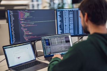 Eine Person arbeitet an einem Schreibtisch mit mehreren Bildschirmen, auf denen Code und Daten angezeigt werden.

(Hinweis: Der von Ihnen bereitgestellte Text enthält keine „ß“-Zeichen, der Inhalt bleibt also unverändert.).