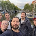 Smarties an der Awwwards Konferenz 2022 Eine Gruppe von sechs Personen macht ein Selfie auf einer Brücke mit einem Kanal und Gebäuden im Hintergrund.