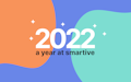 In der Mitte eines bunten Hintergrunds mit orangefarbenen und blaugrünen Klecksen und kleinen weißen Glitzersteinen steht ein fettgedruckter weißer Text: „2022, ein Jahr bei smartive“.