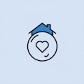 Ein einfaches Symbol, das ein Haus mit einem Herz in einem Kreis davor auf einem hellblauen Hintergrund zeigt.