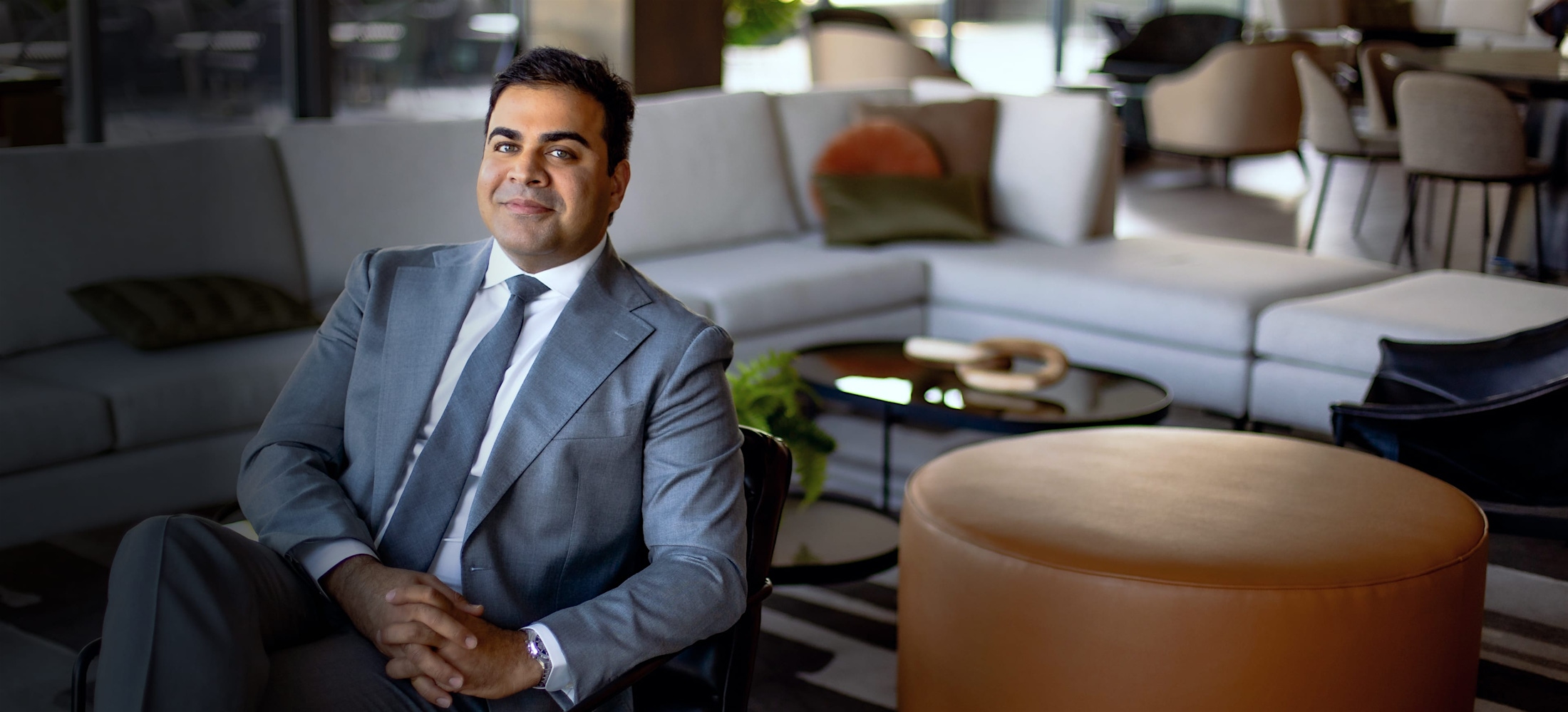 Dr. Chopra in a suit, sitting down