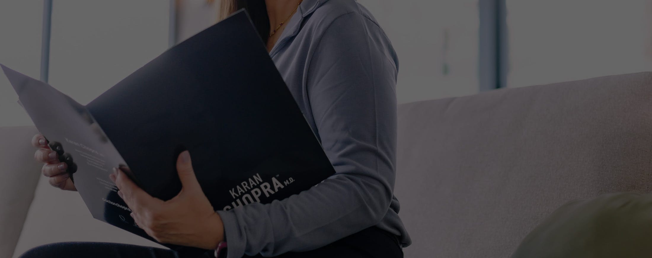 woman reading information about Dr. Chopra