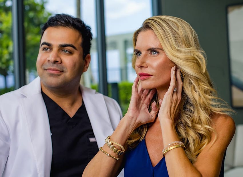Dr. Chopra with patient while she touchs her jaw