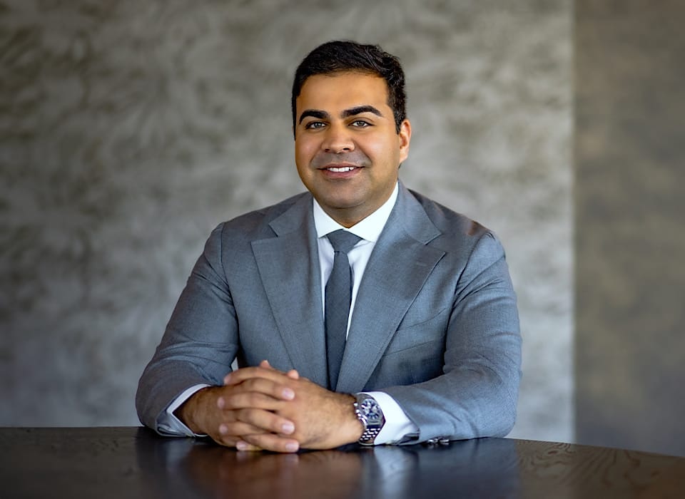 Dr. Chopra in suit sitting down