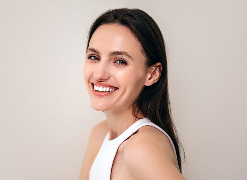 woman smiling in white tank top