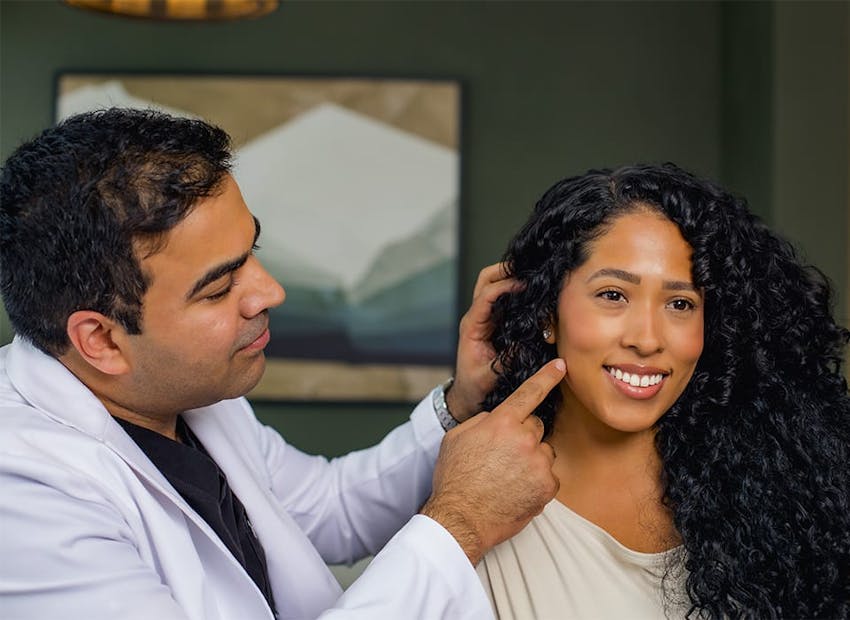 Dr. Chopra pointing to patient's jaw