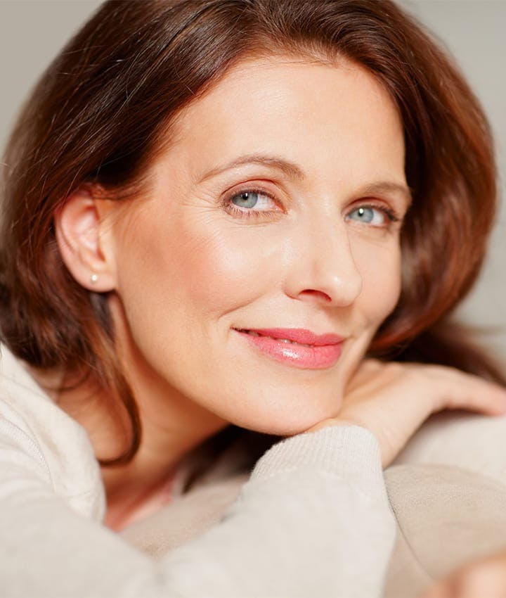 close up of woman smiling and leaning on her hand