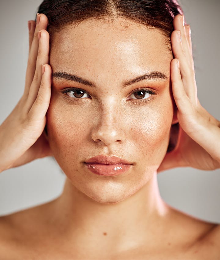 close up of woman touching both sides of her face